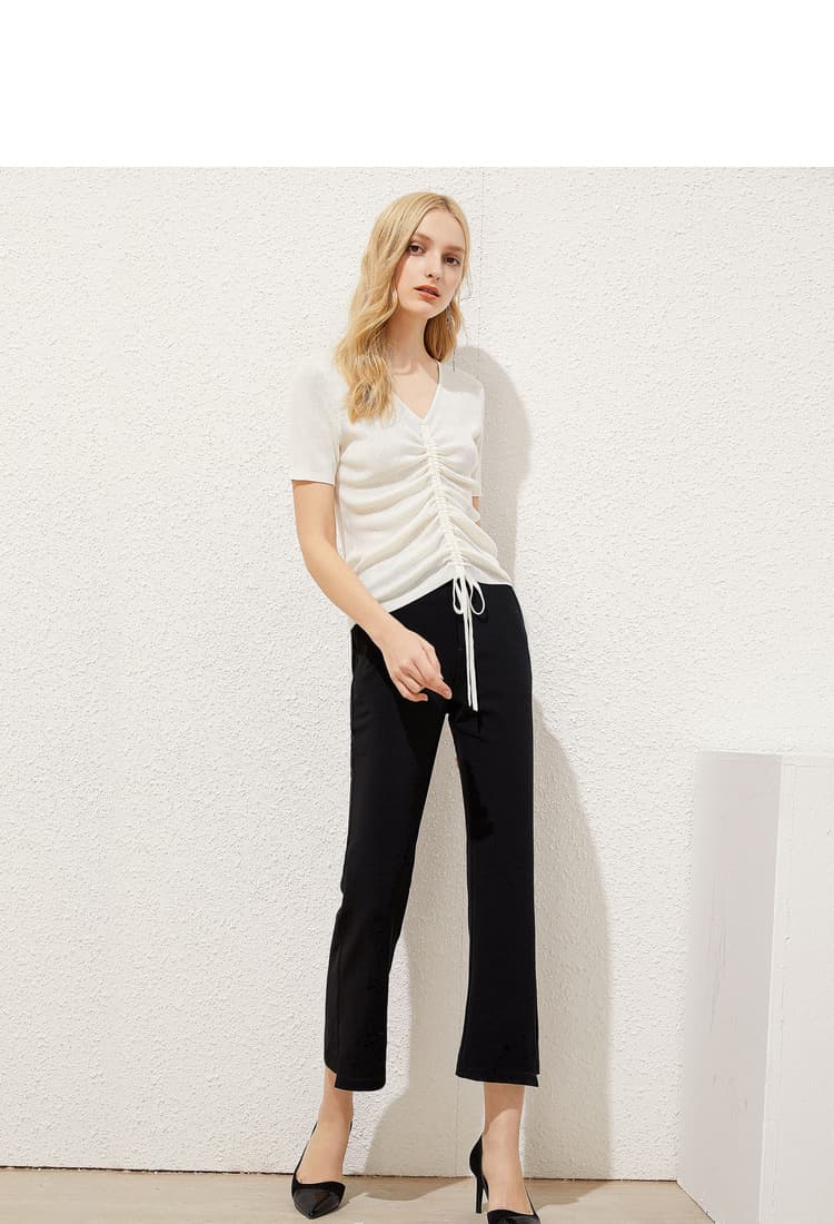 Ivory gathered V-neck knit tee styled with black trousers