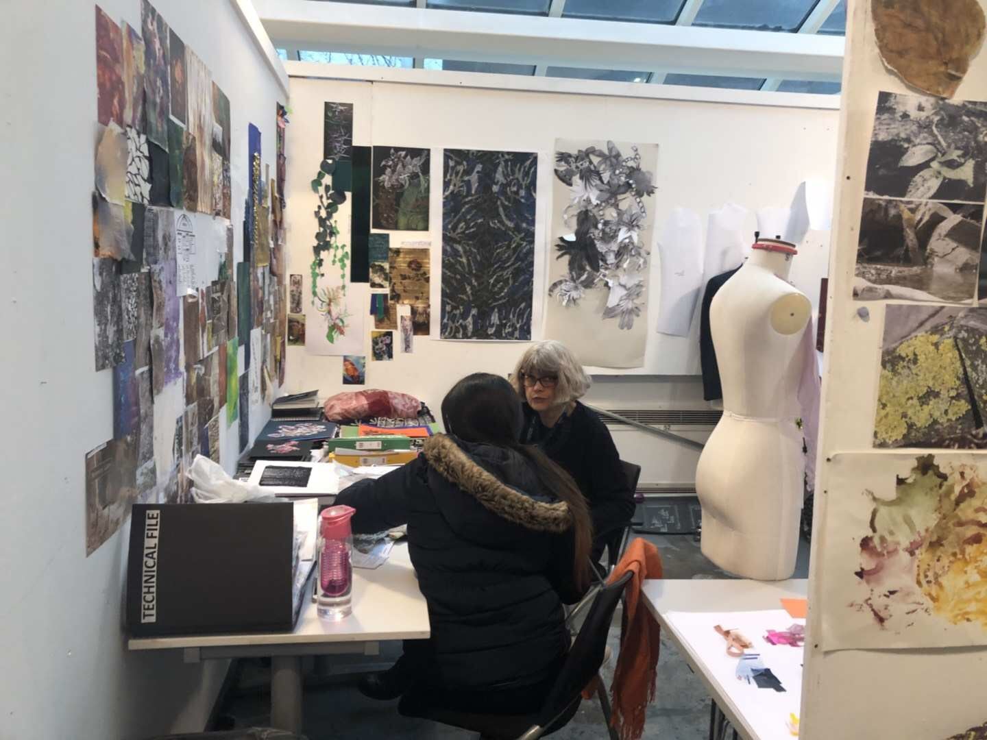 Designers developing garment references in a studio with collection and fabric boards