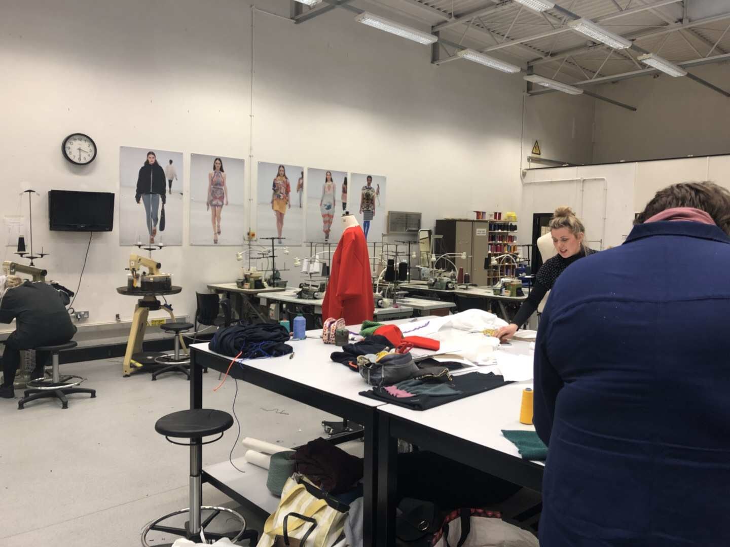 Garment development workroom with pattern tables, dress forms and sample references