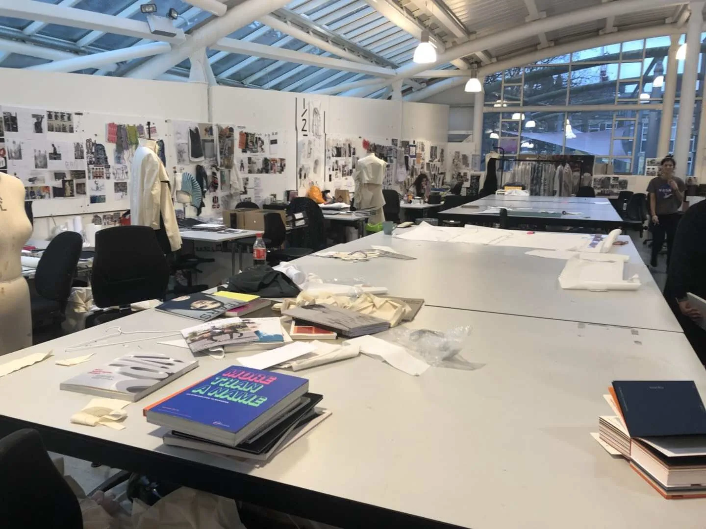 Garment pattern pieces and development references laid out across a sample-room worktable