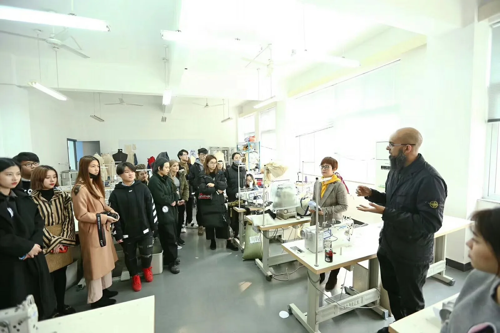 Group reviewing sample development and garment construction at a pattern-room table