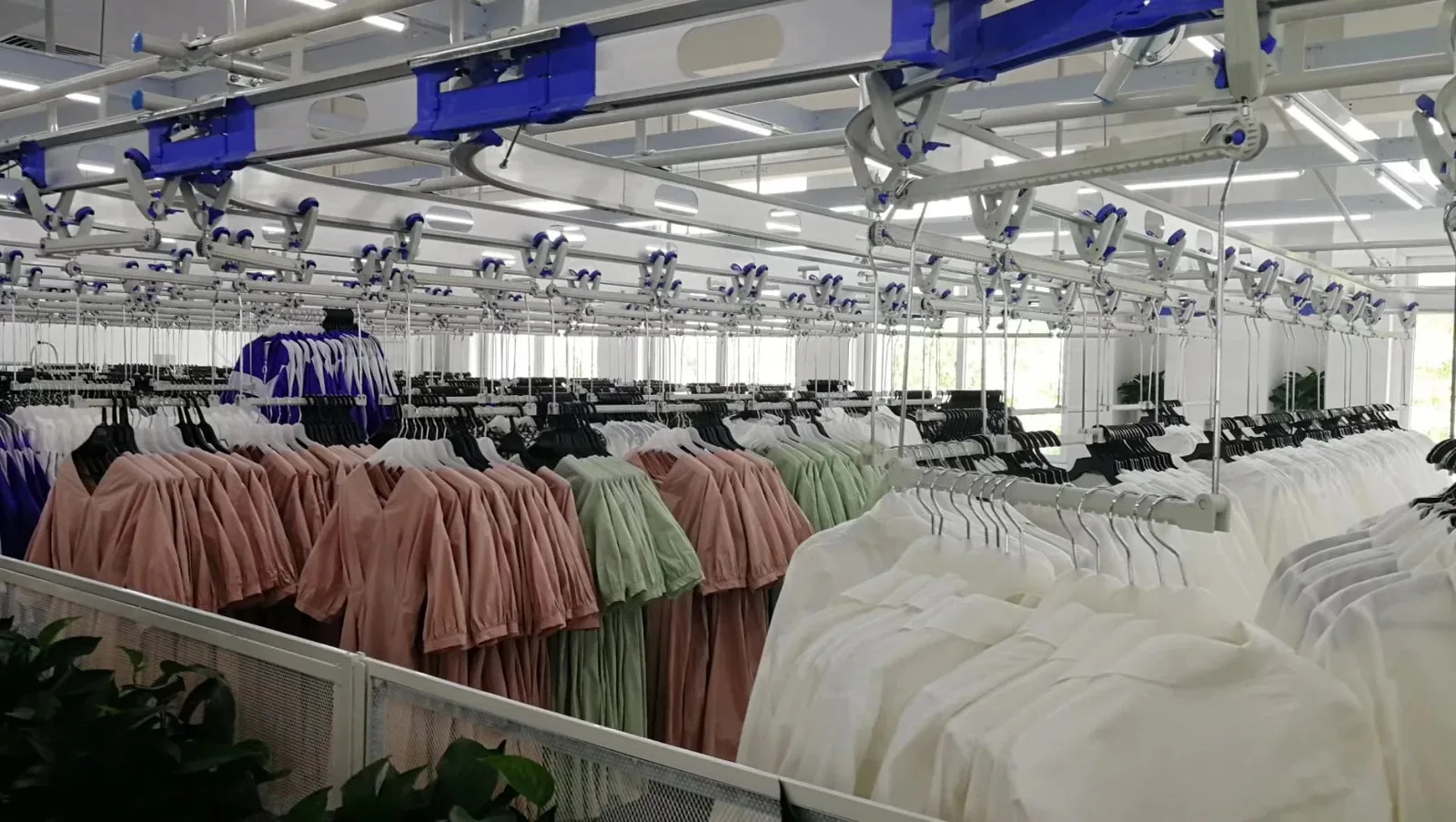 Garments grouped on a suspended handling line, illustrating the current work-in-progress that must be checked before scheduling a repeat order