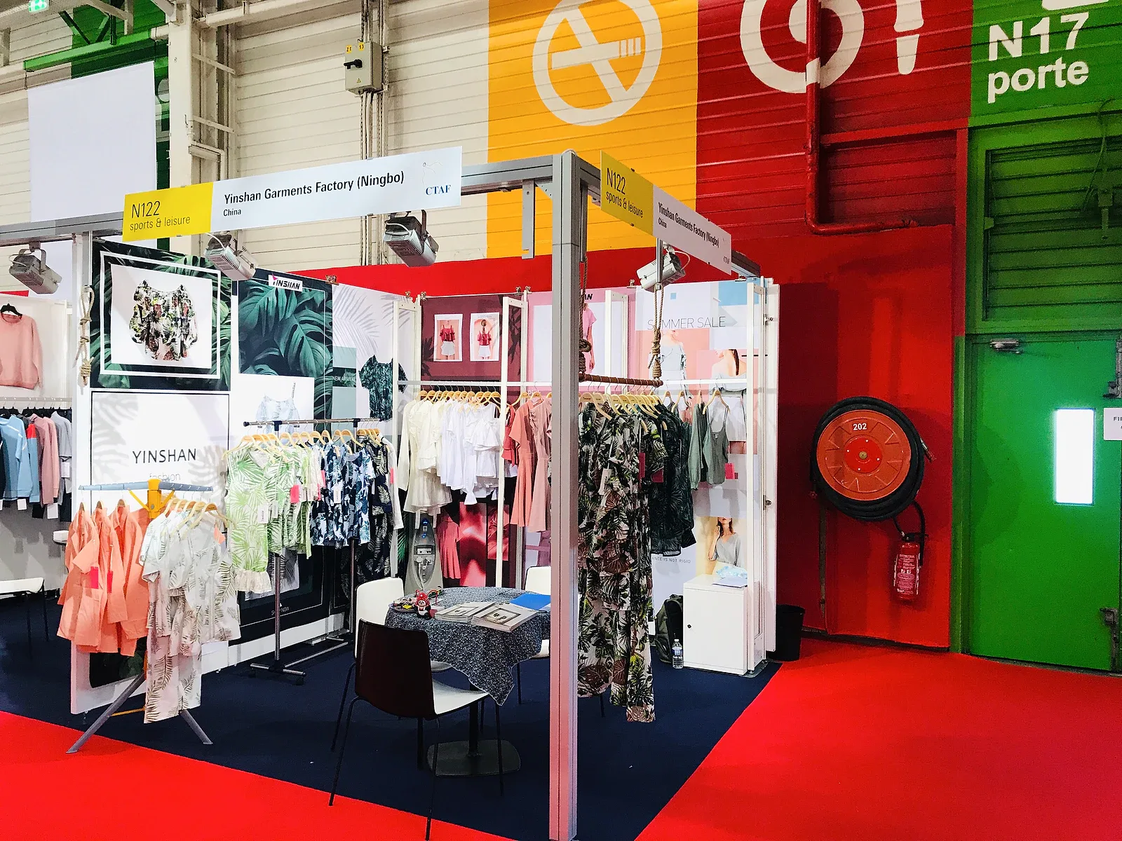 Yinshan Garments Factory trade show booth displaying apparel collections for international buyers.