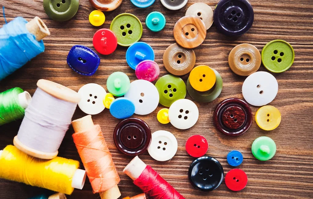 Buttons and sewing threads illustrating the trim variables in a style-colour-size order plan