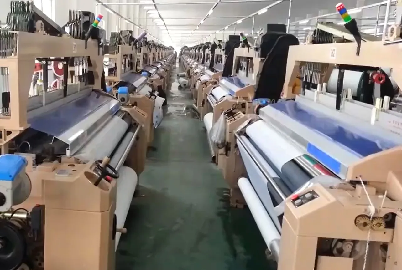 Modern weaving machines at a Yinshan Fashion partner fabric factory producing woven greige fabric