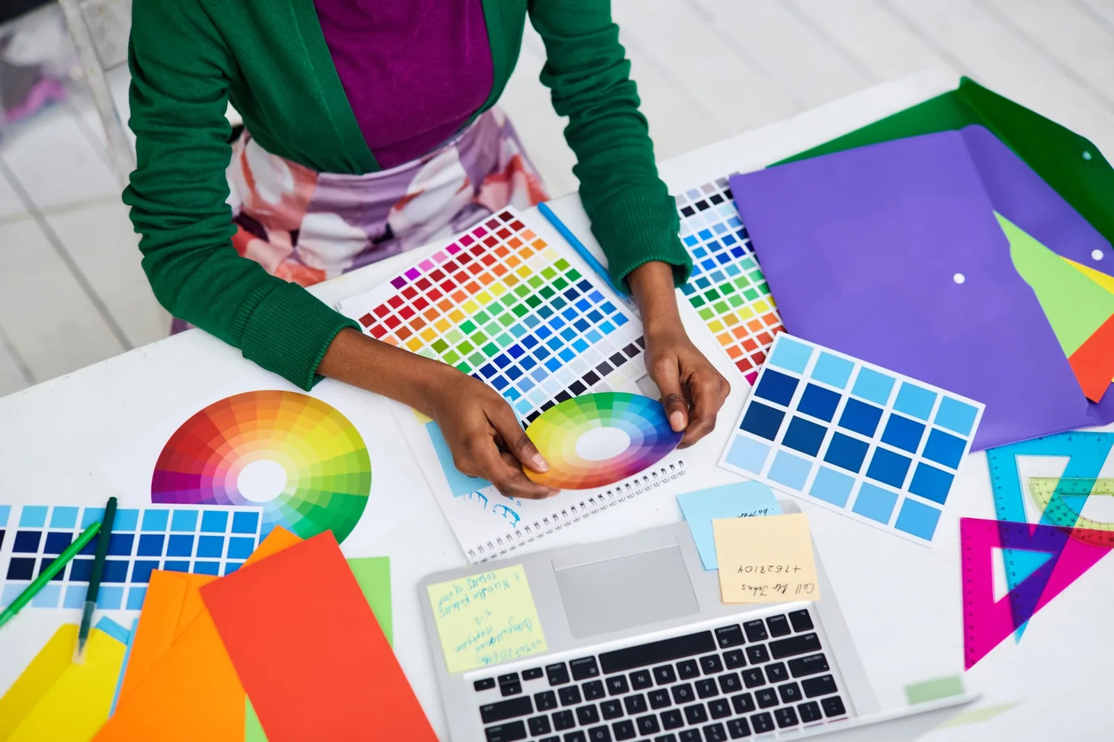 Designer comparing colour swatches and fabric references before preparing a product brief