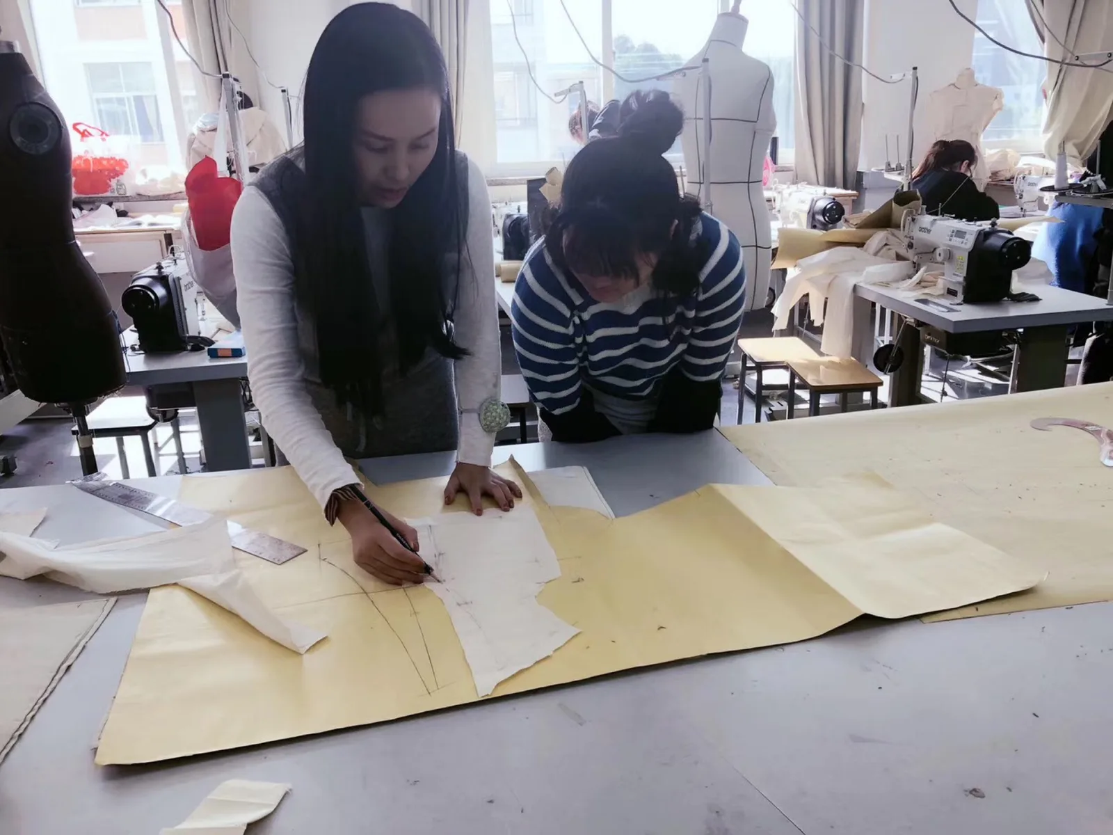 Yinshan Fashion pattern-making team reviewing garment measurements and construction details during sample development